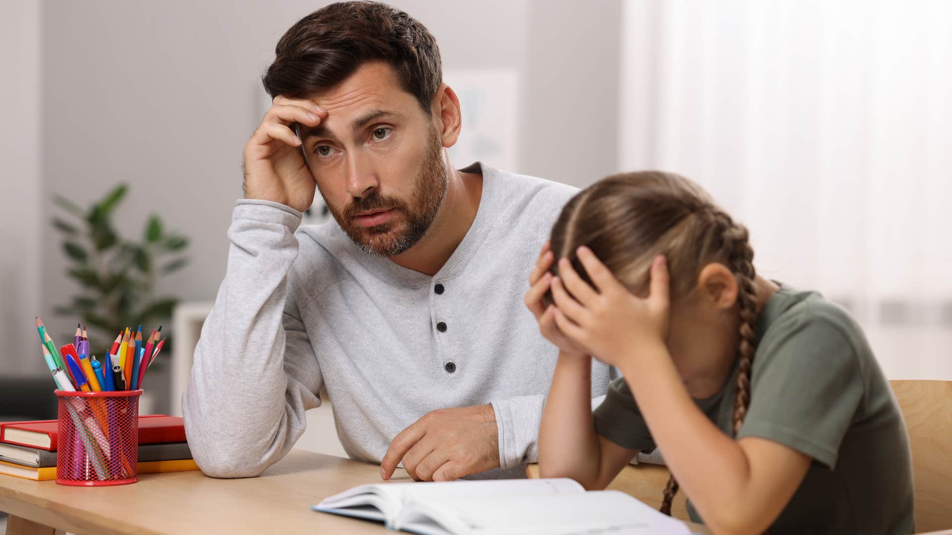 man who babysits his own kids doing homework together