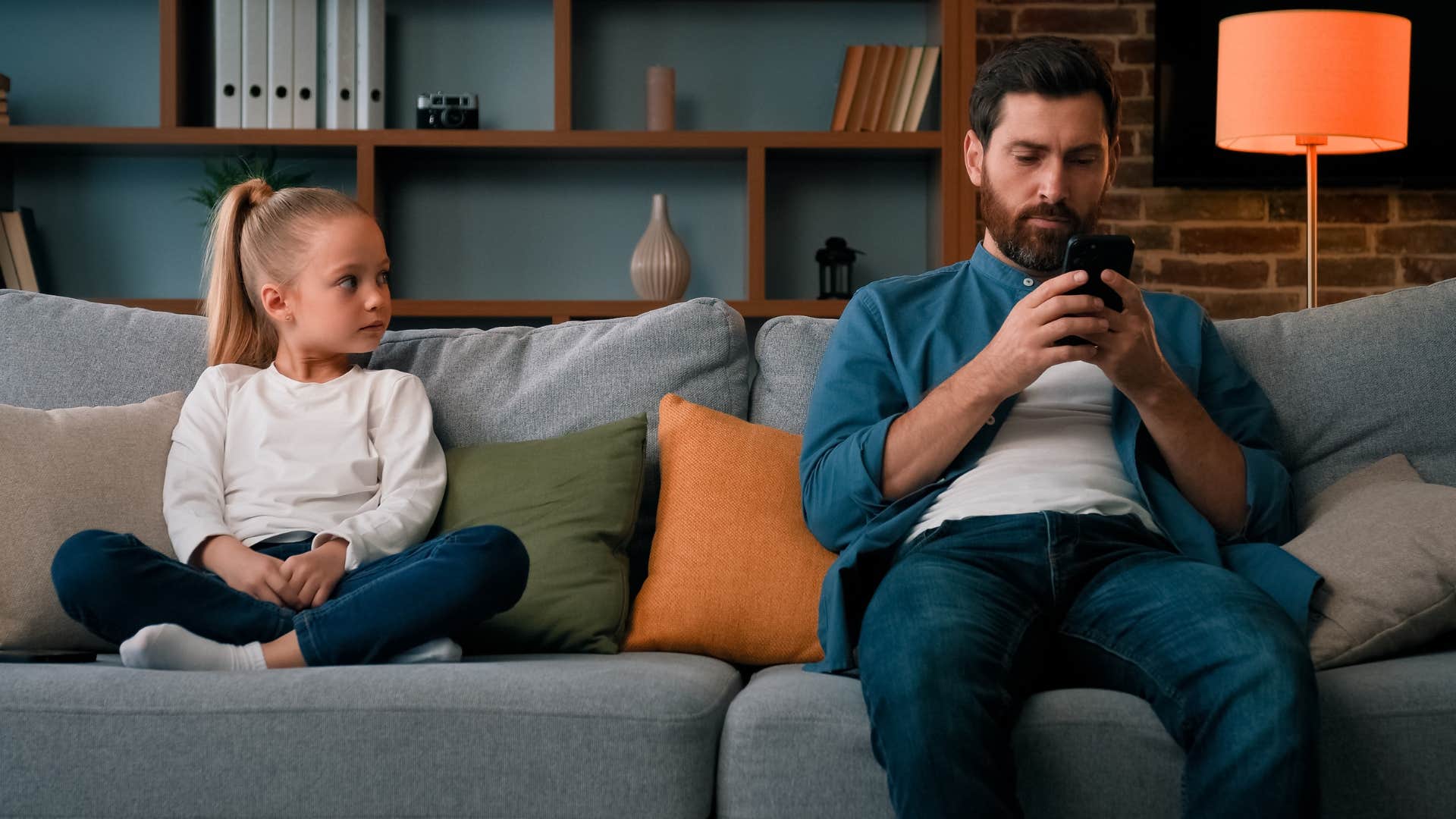 man who lacks curiosity about his family on his phone instead of spending time with daughter