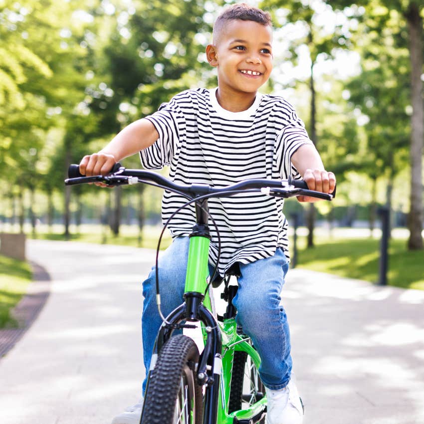 Kid riding bicycle without a helmet outside like kids in the 1970s used to do