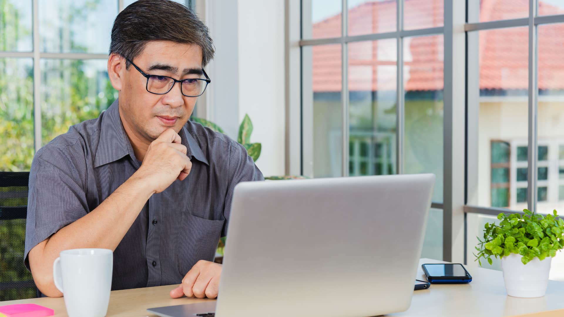 confused older man on his computer accidentally copying managers on emails