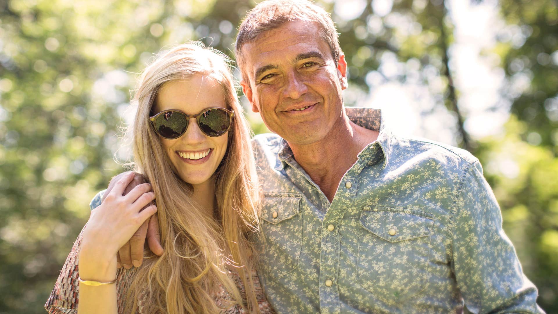 Consistent man smiling with his partner outside.