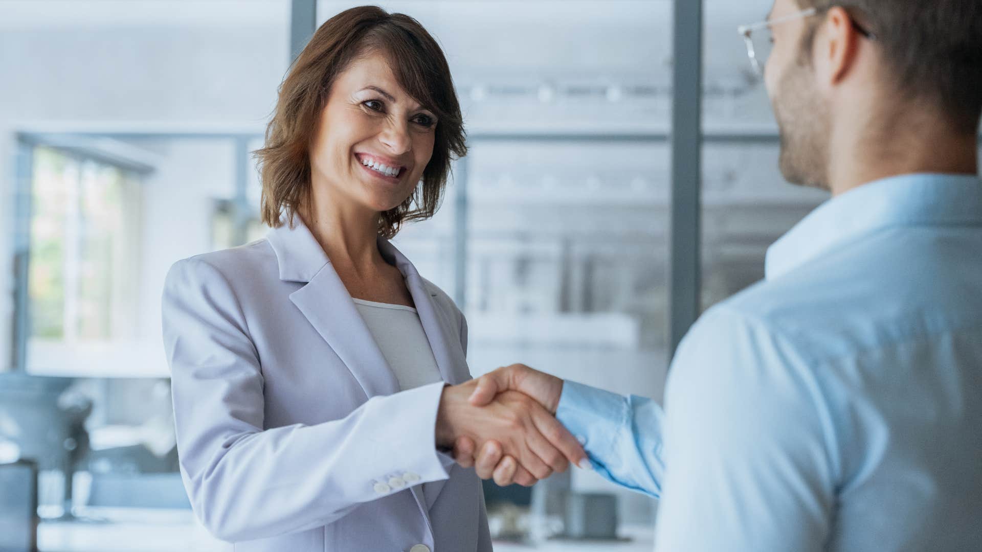 woman who doesn't overshare immediately shaking hands at work