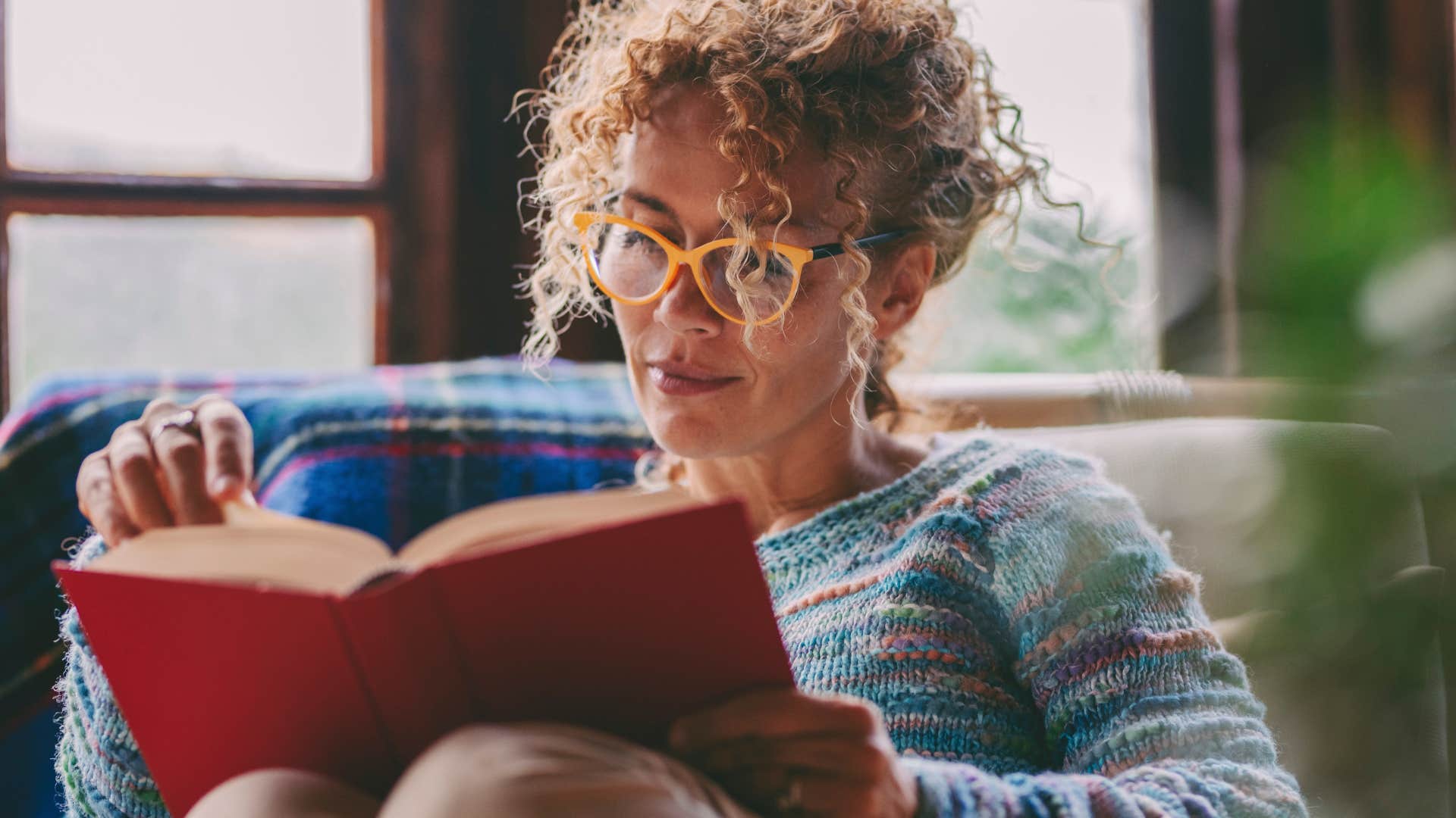 older woman who enjoys their alone time reading a book at home