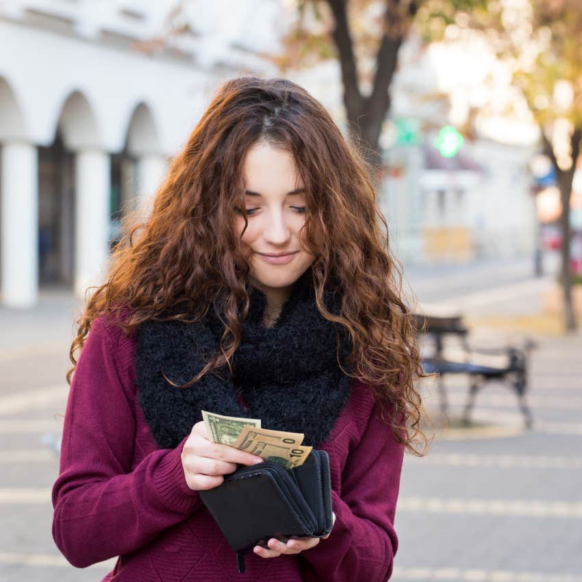 woman counting money in wallet