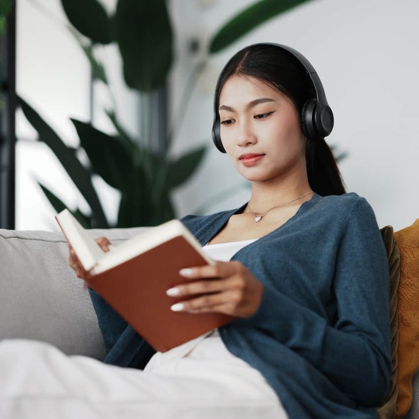 woman taking time away from technology by reading and listening to music