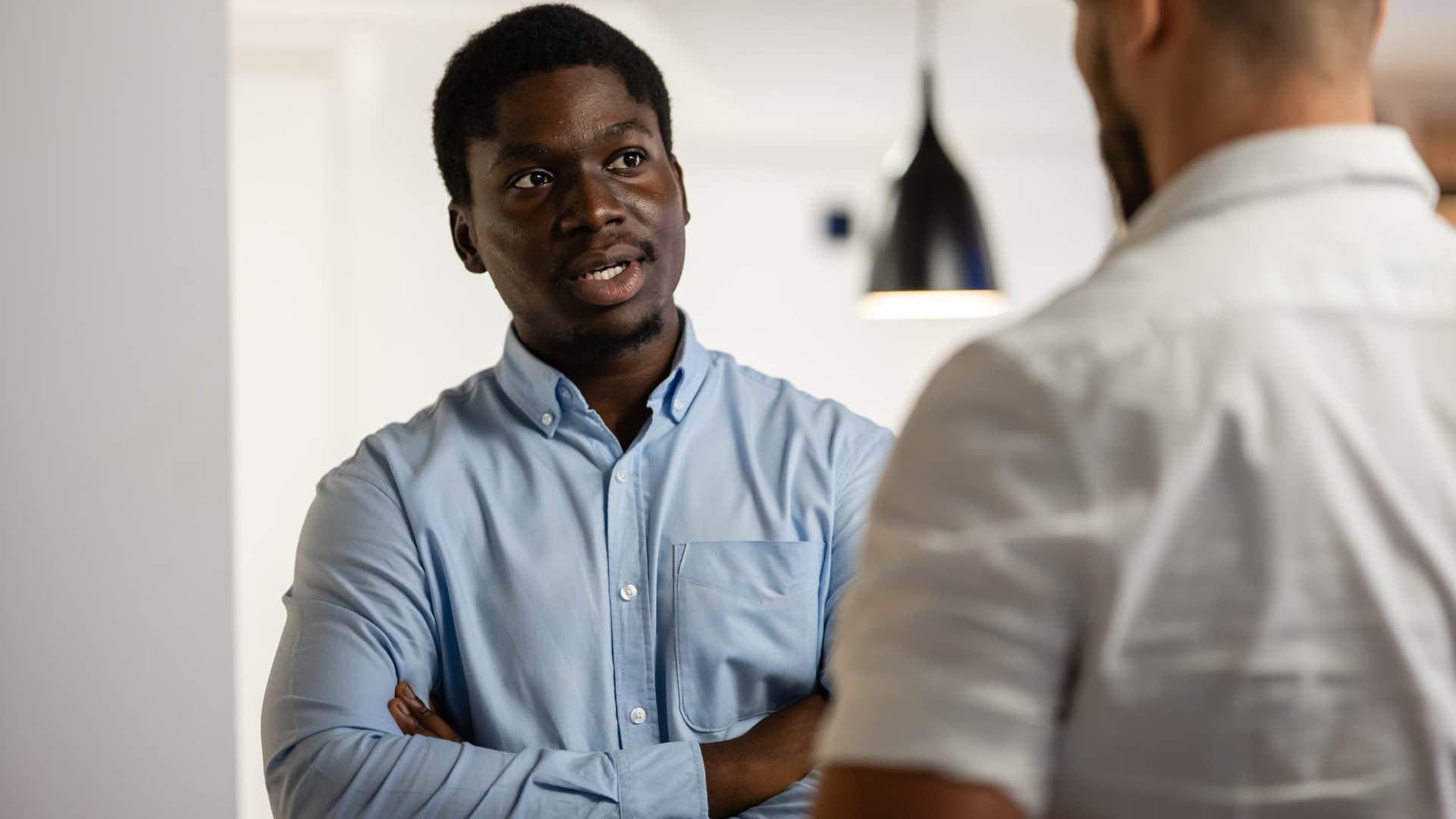 man saying that's their job to concerned colleague at work