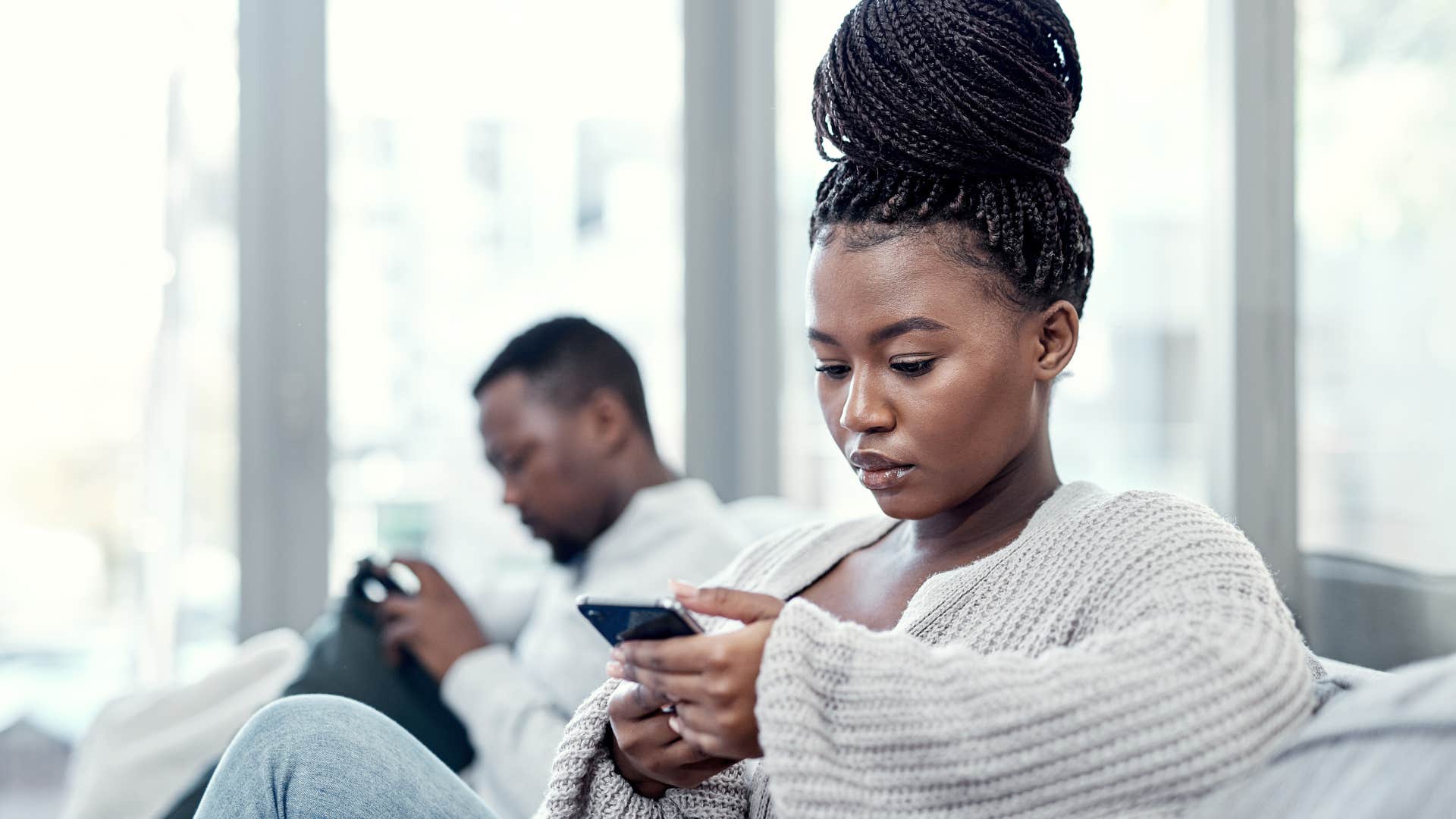 woman on her phone ignoring husband and telling him i don't care