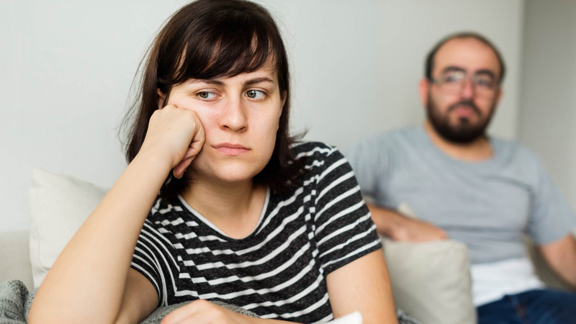 frustrated wife turned away from her husband saying you're impossible