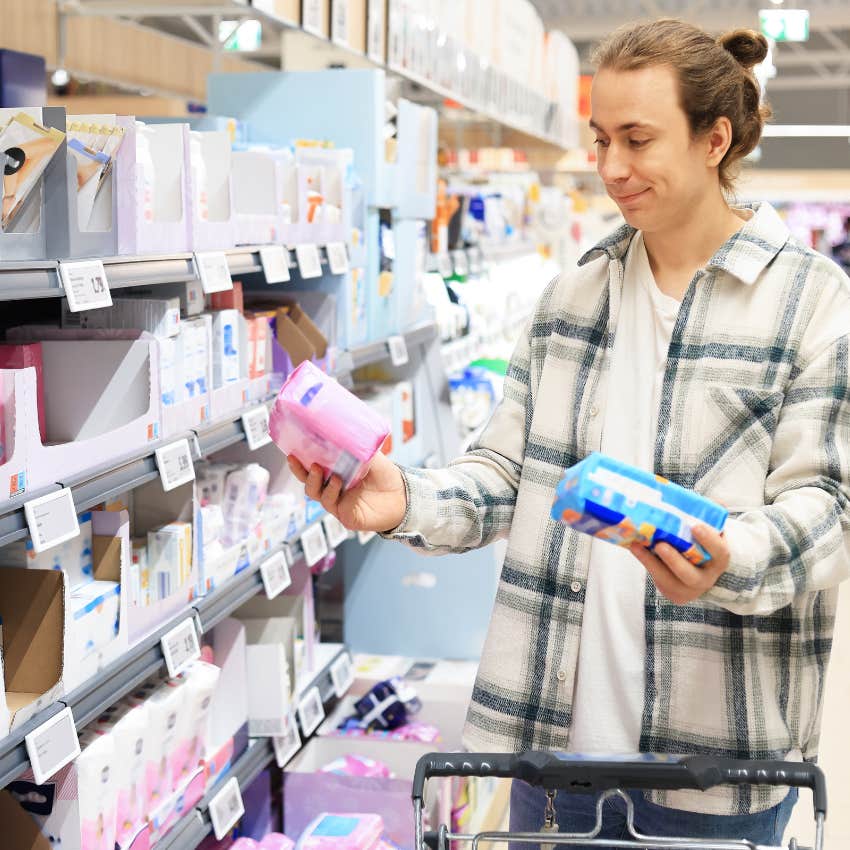 man embarrassed and confused buying feminine hygiene products