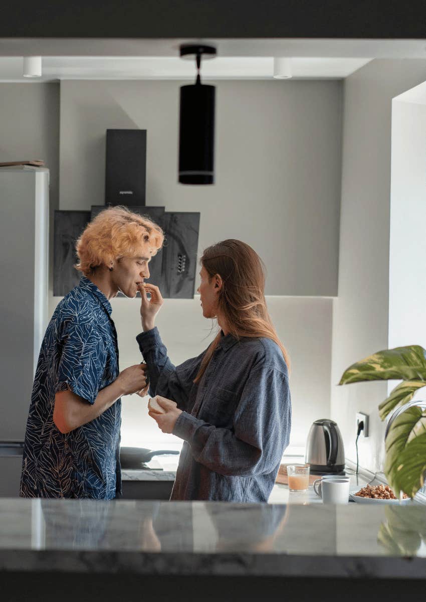 woman feeding man a piece of food