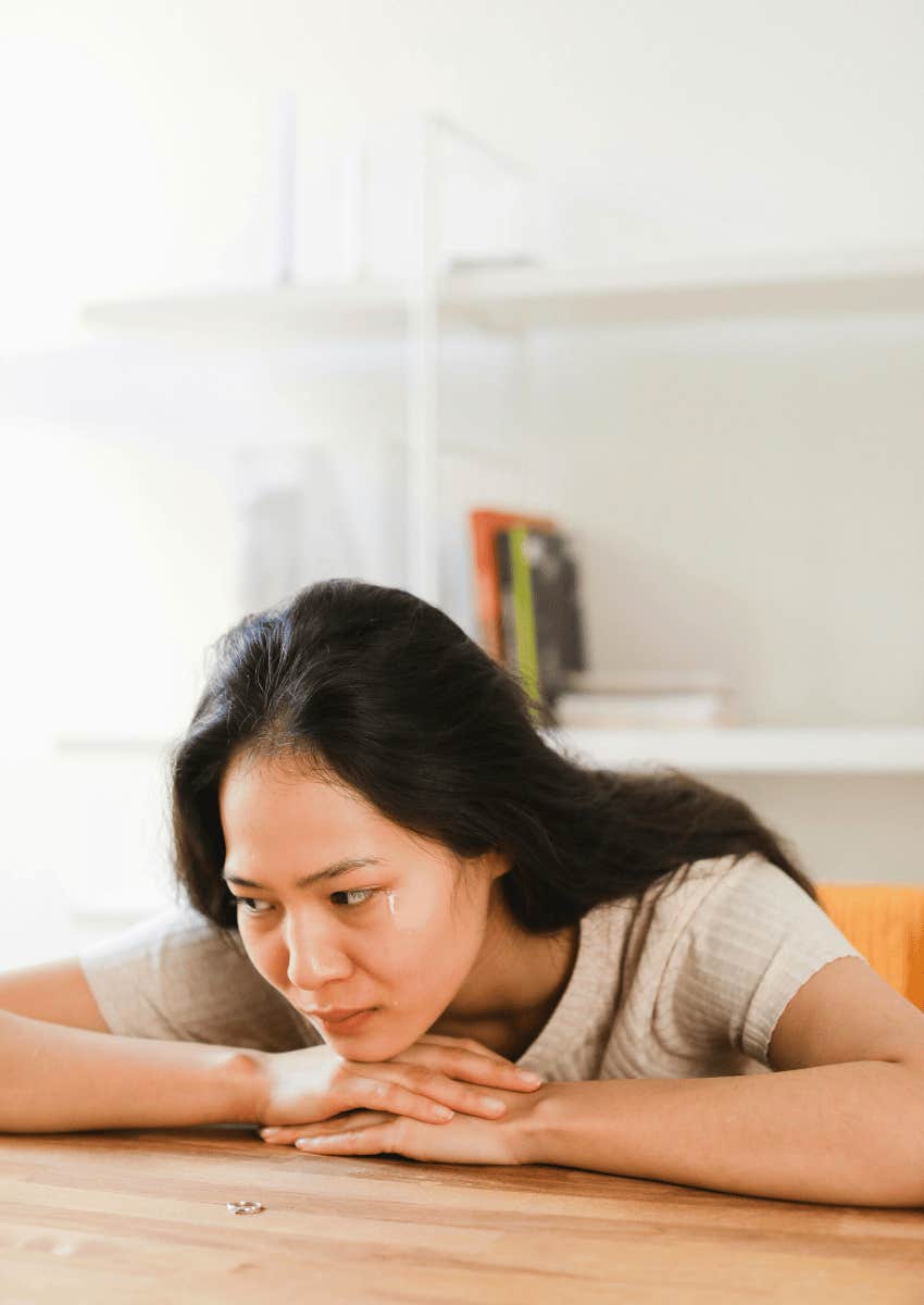 woman with her head on her hands crying