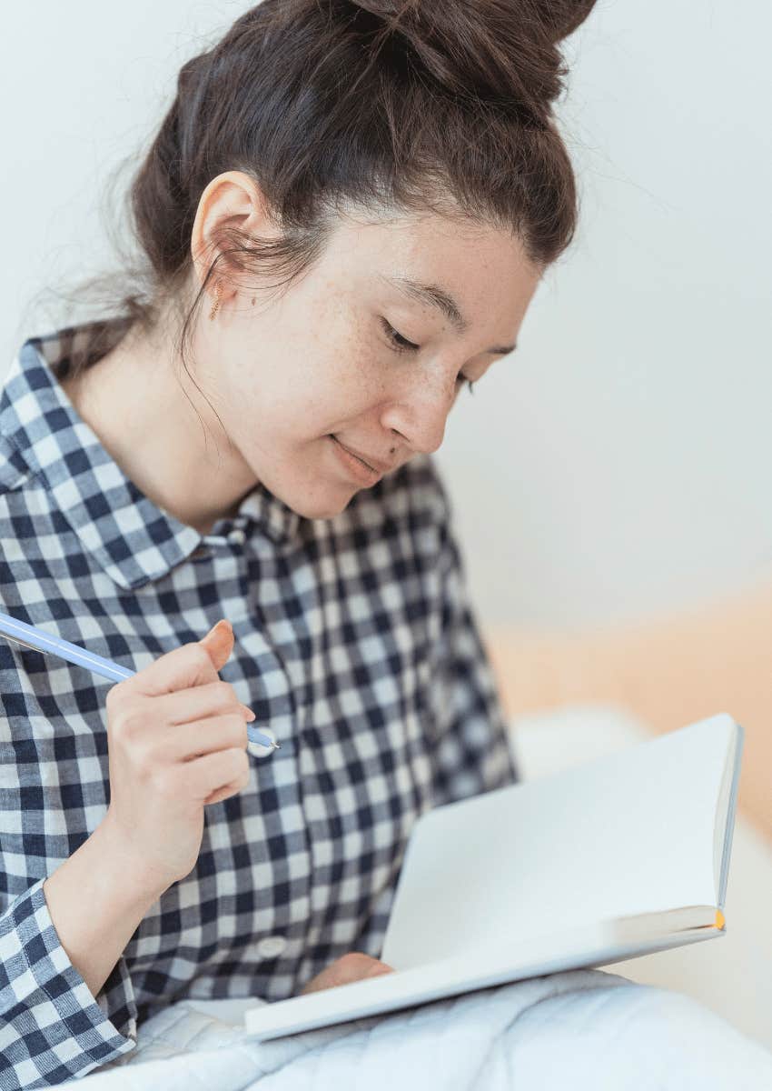 woman writing in a gratitude journal