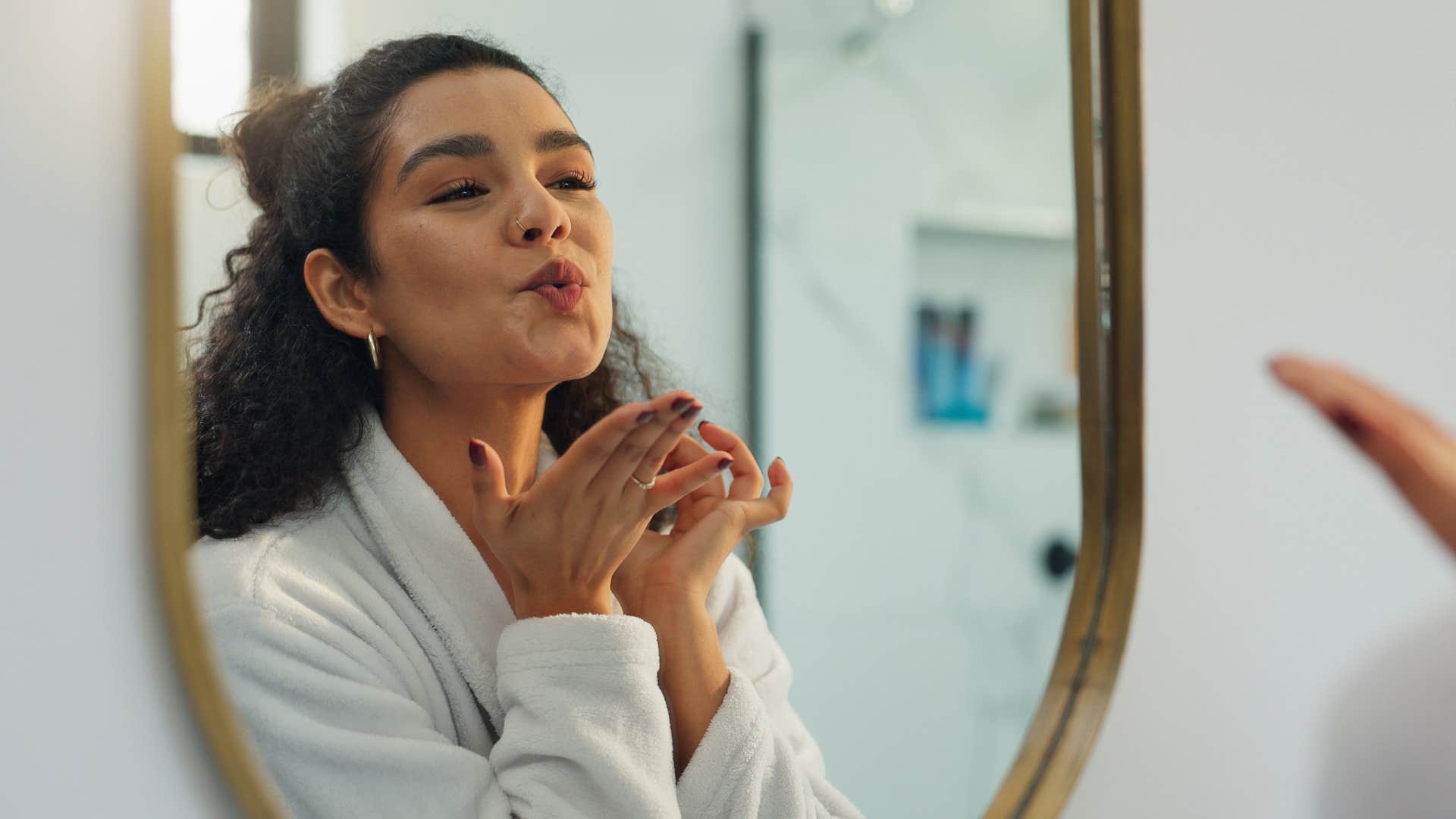 Woman who cares about consistency smiling in the mirror.