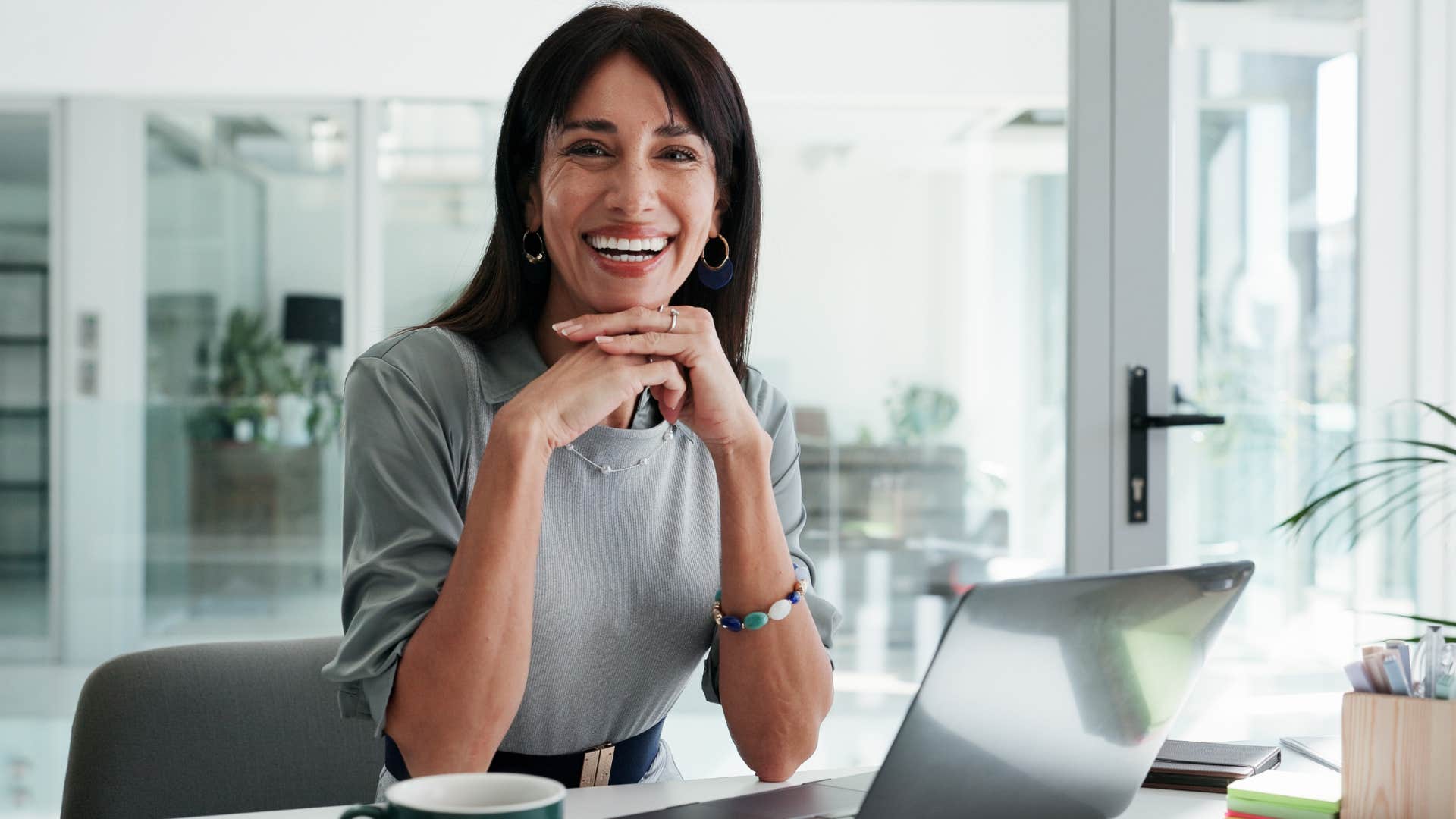 Woman who's confident and self-assured sitting at her work desk.