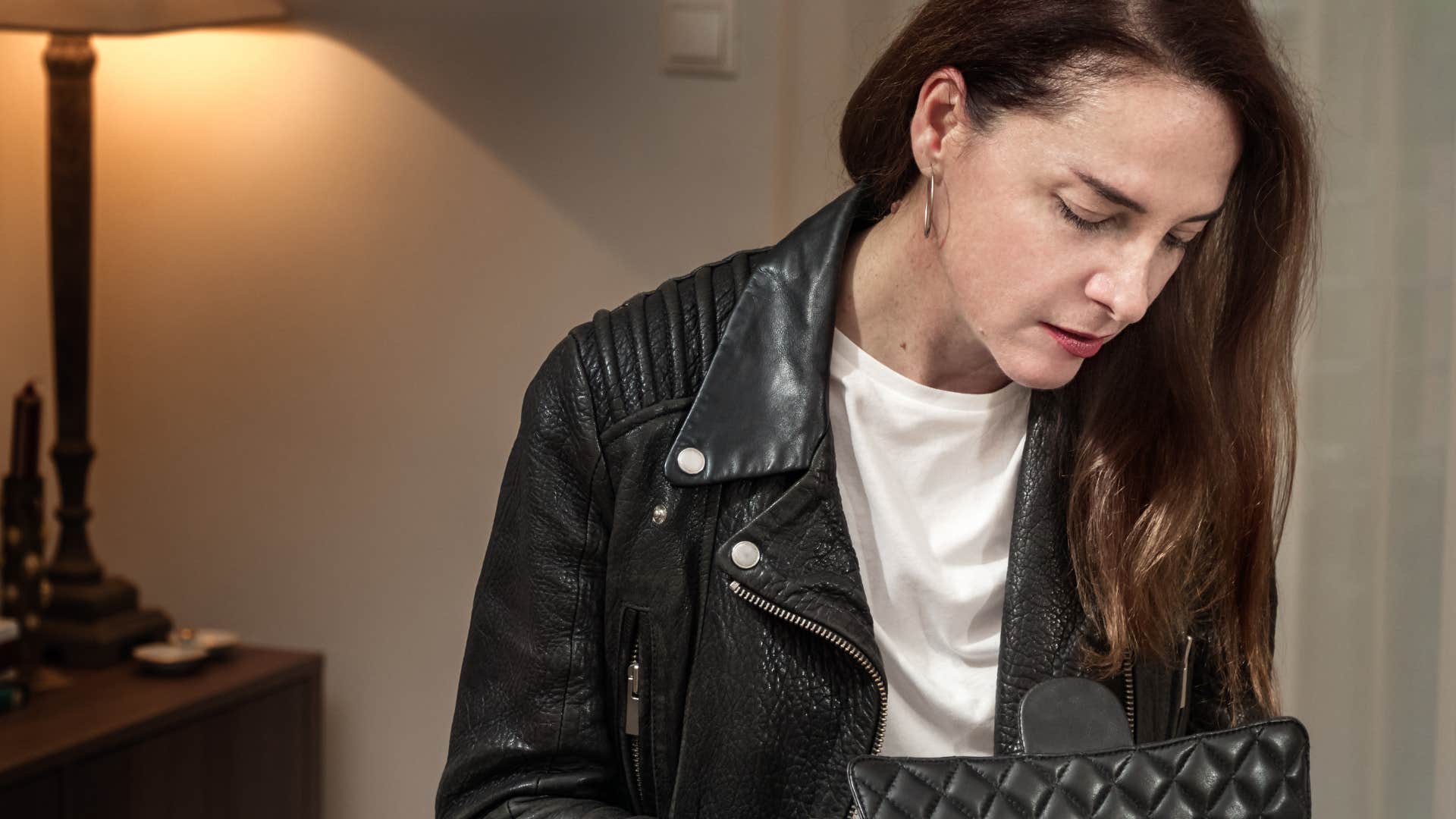 Detail-oriented woman looking in her purse for lip gloss.