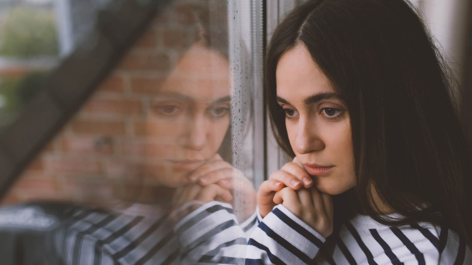 woman who doesn't enjoy surprises looks out the window