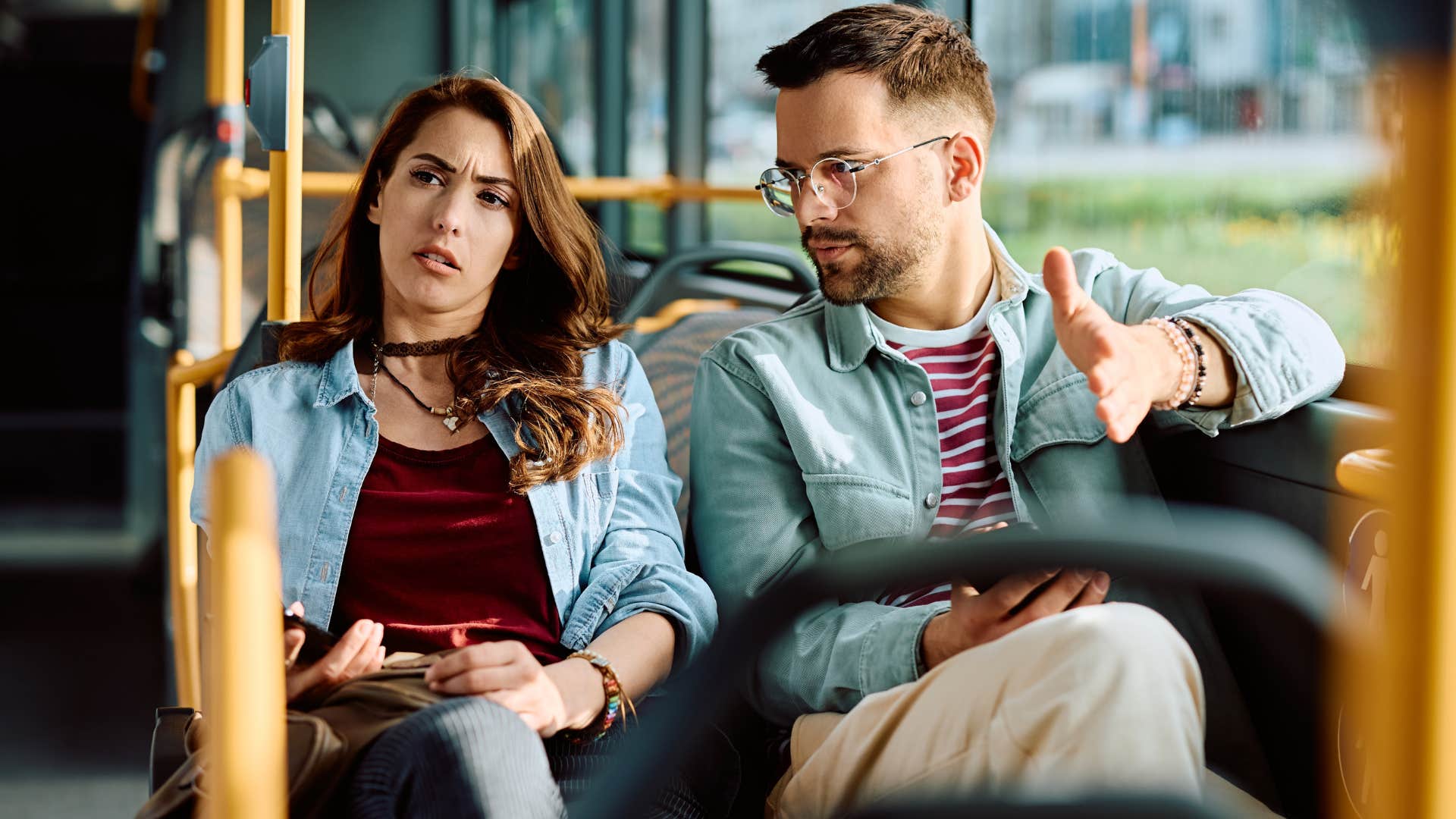 woman saying don't mind him with her partner on the bus