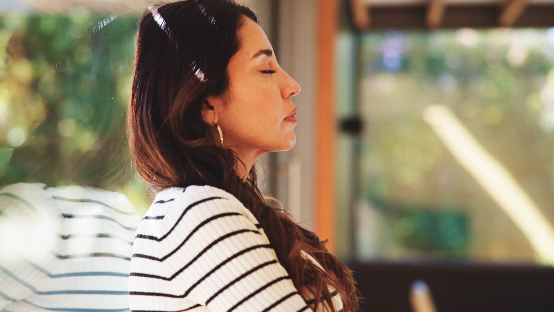 relaxed woman solving conflicts internally leaning against a window
