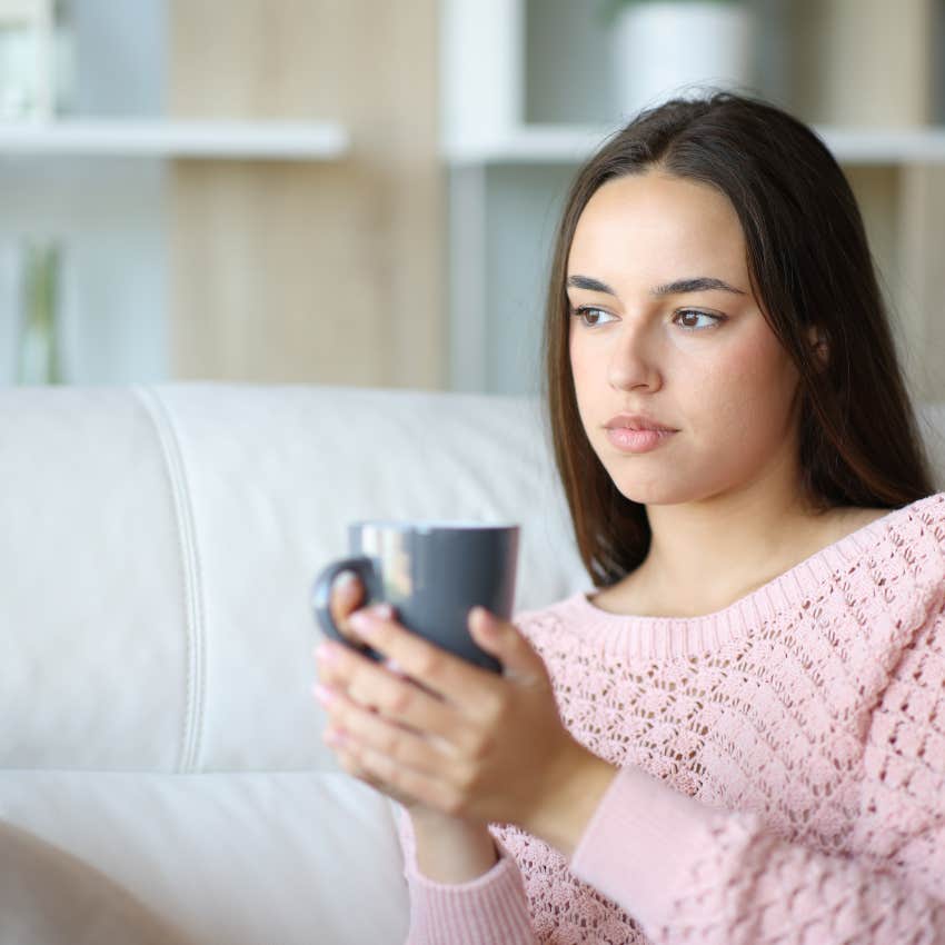 woman holding mug while sitting on couch