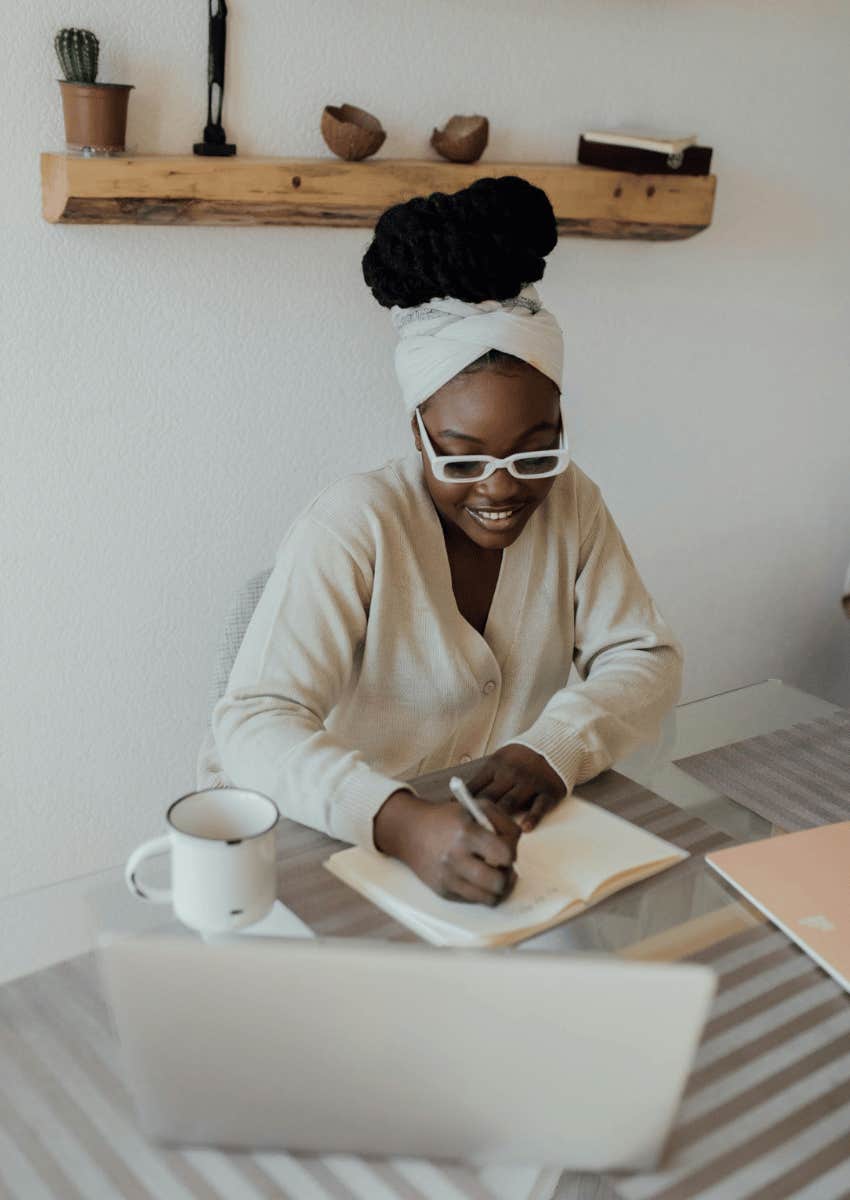 young woman in glasses journaling