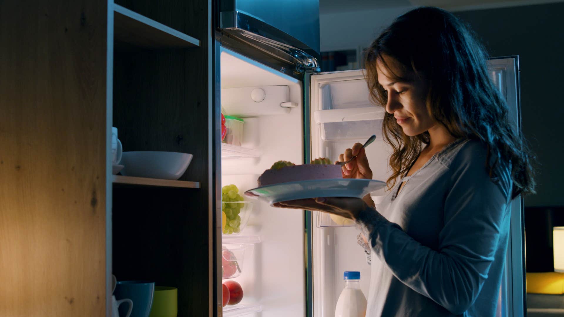 Person eats cake late at night showing bad indulgence habit
