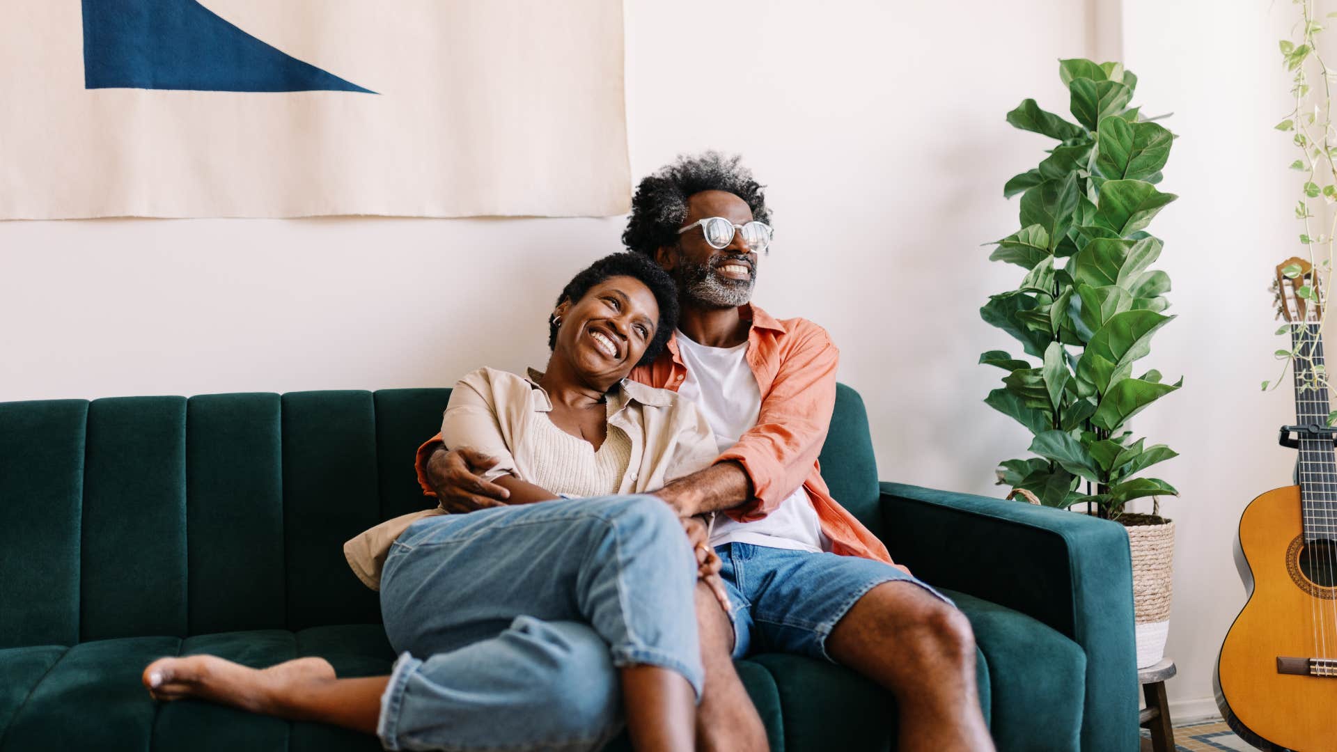 couple cuddling on the couch with supportive husband telling his wife i'm here for you no matter what