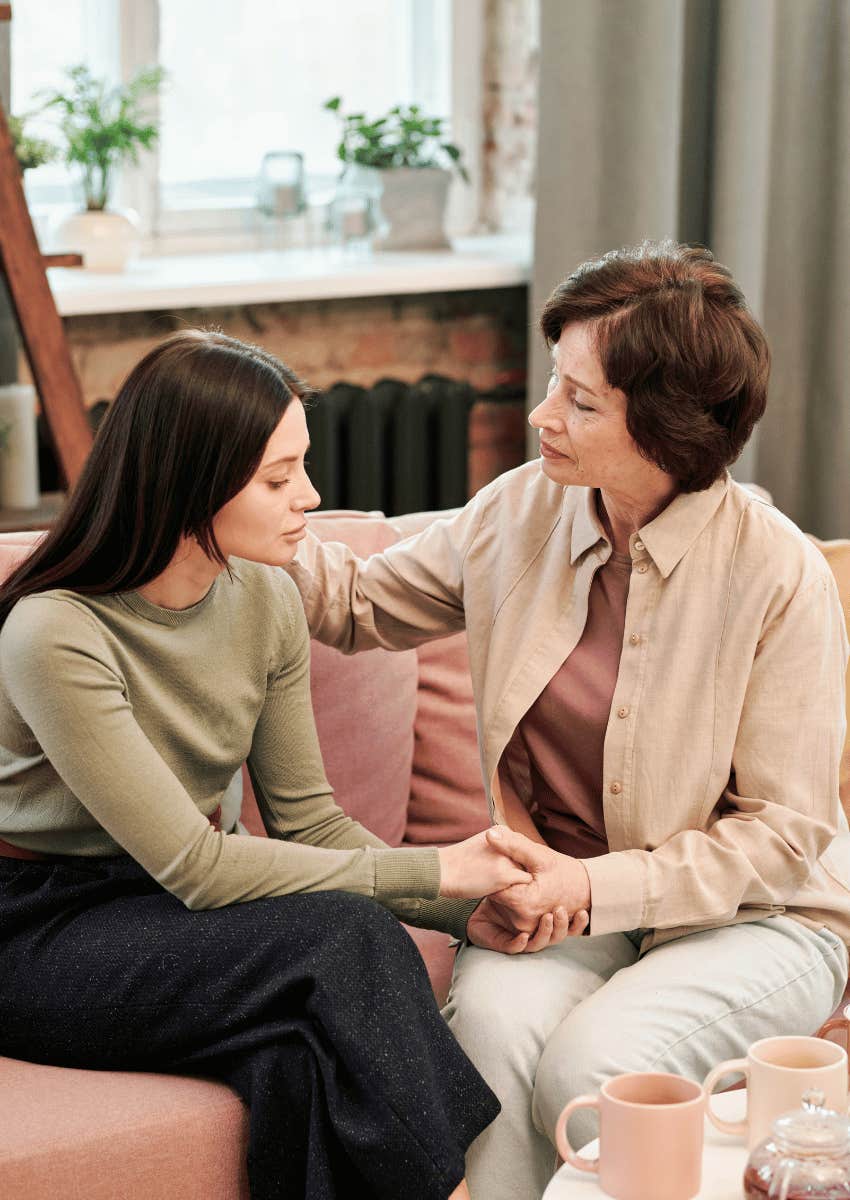 adult daughter holding hands with her older mom