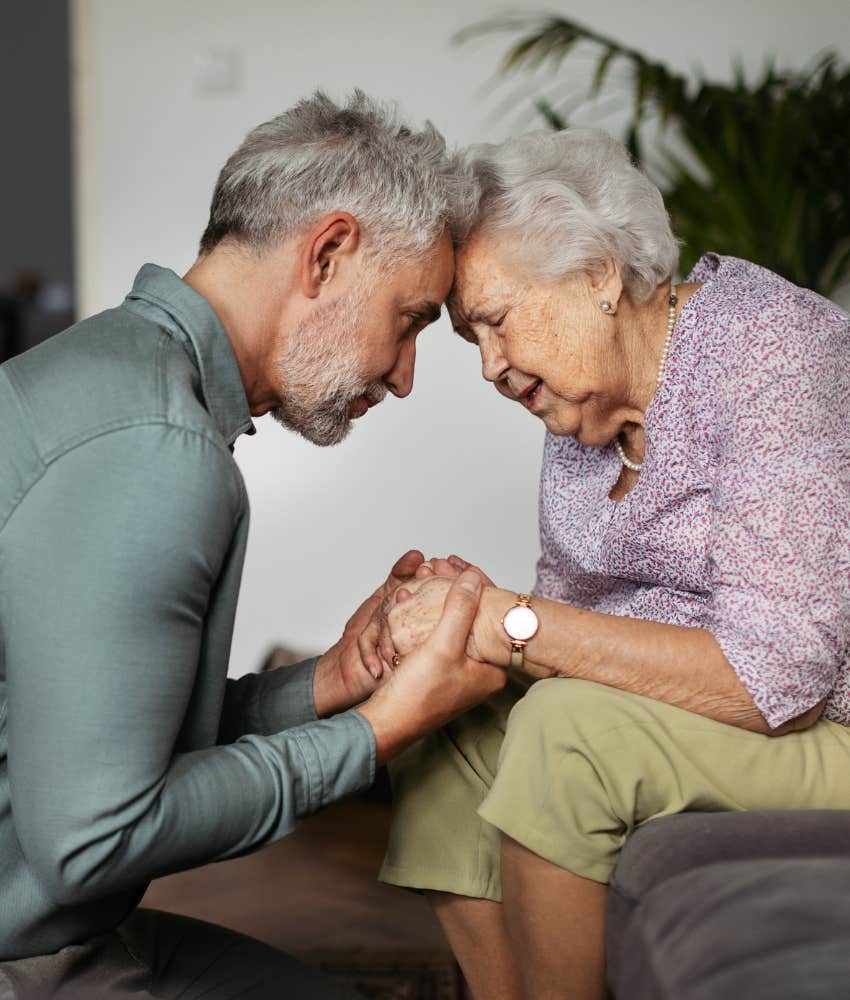 Mature man comforts senior mother showing responsibility