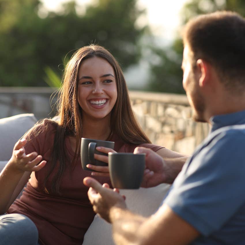 charismatic woman talking to man holding mug