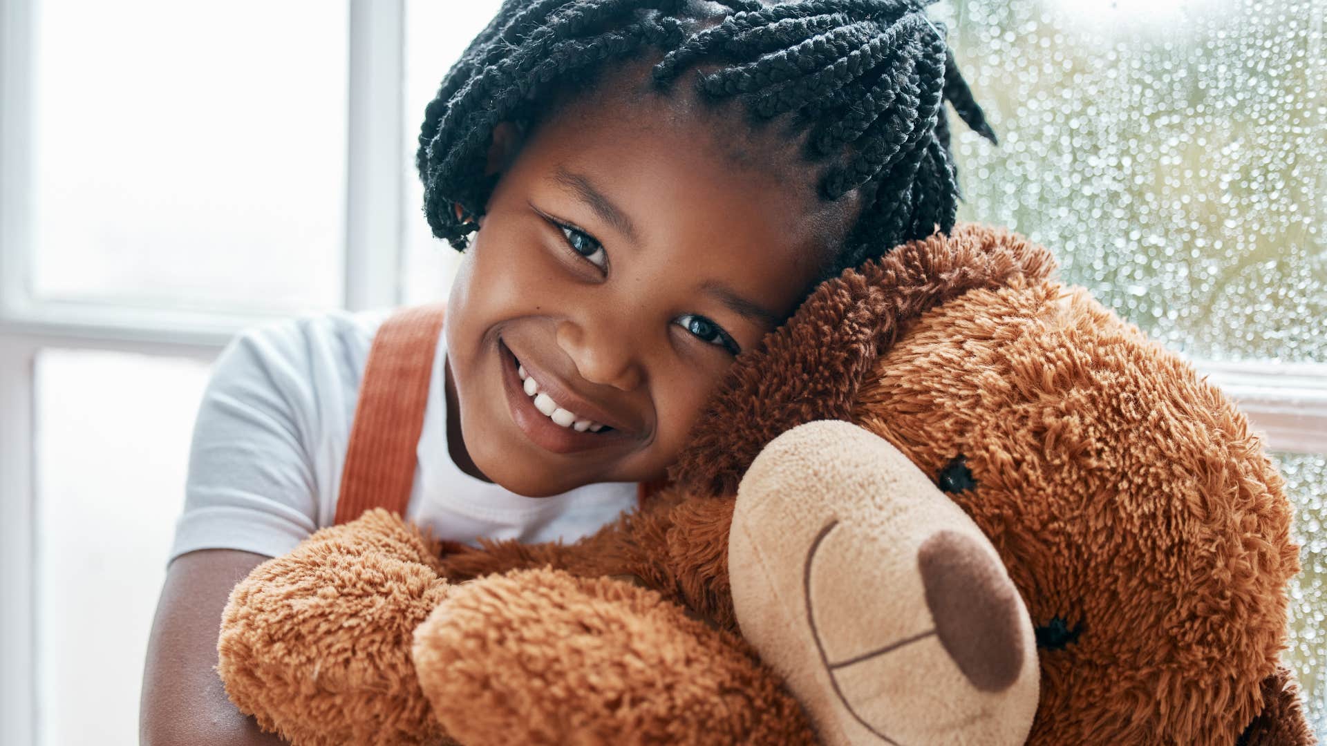 Little girl who learned to appreciate small things smiling with her toy.