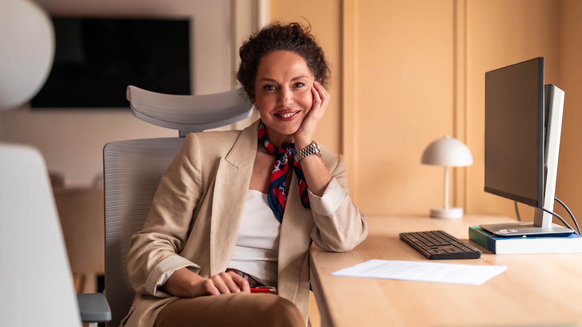 smiling professional sits at desk showing safety in job