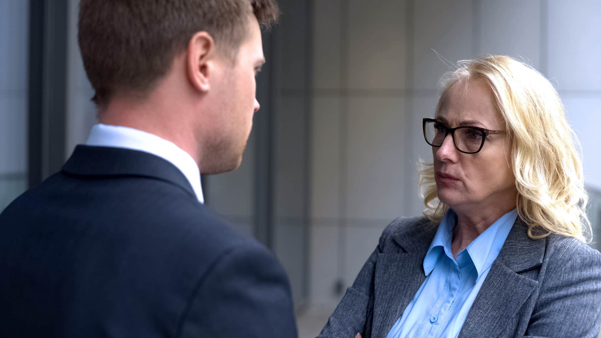 Annoyed professional with colleague showing feeling stuck in job