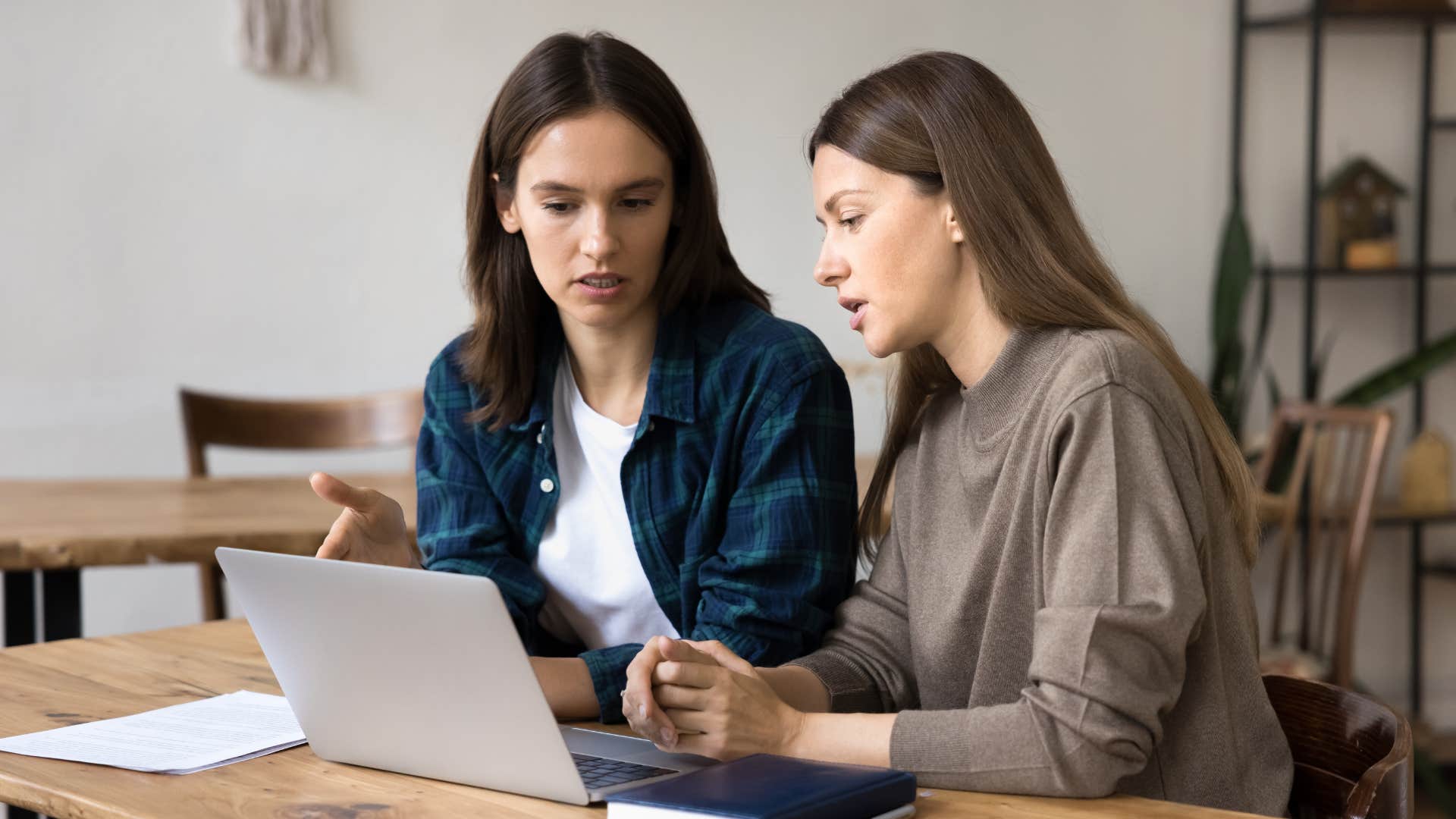 Career coach with laptop advises job seeker about online persona