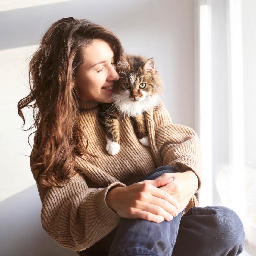 woman with cat resting over shoulder