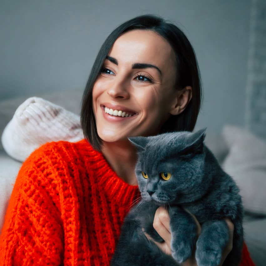 woman holding grey cat whose purr never changes