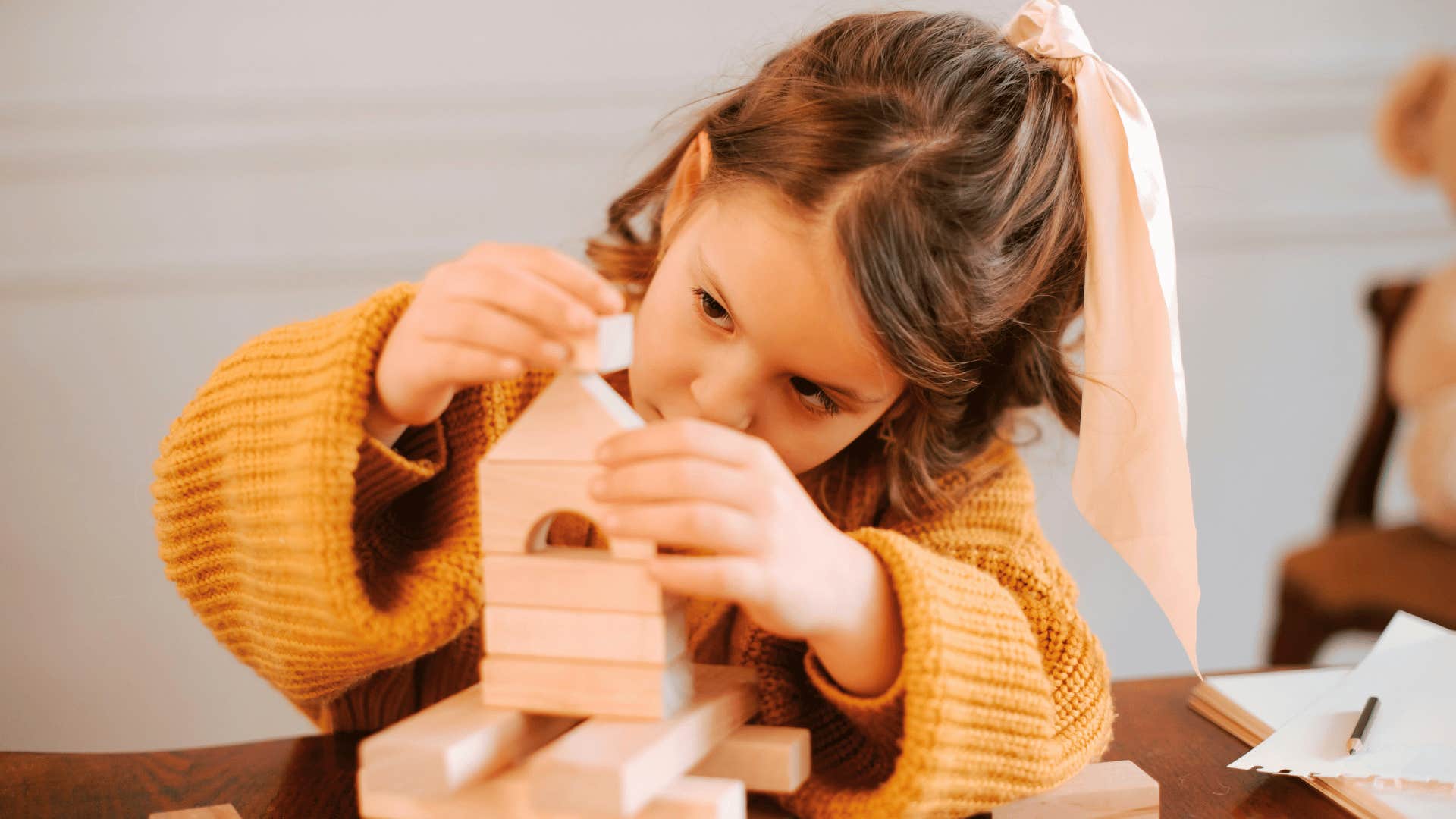 child focusing on building blocks