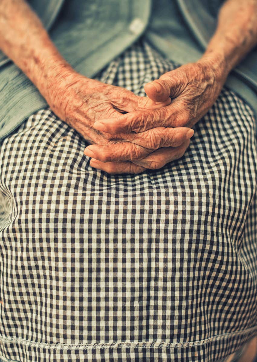 close up of older woman's hands resting on lap