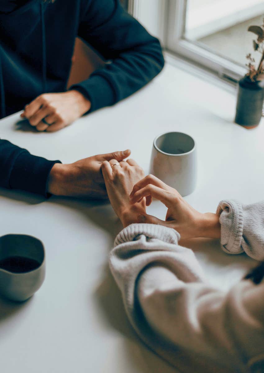 couple holding hands across a table
