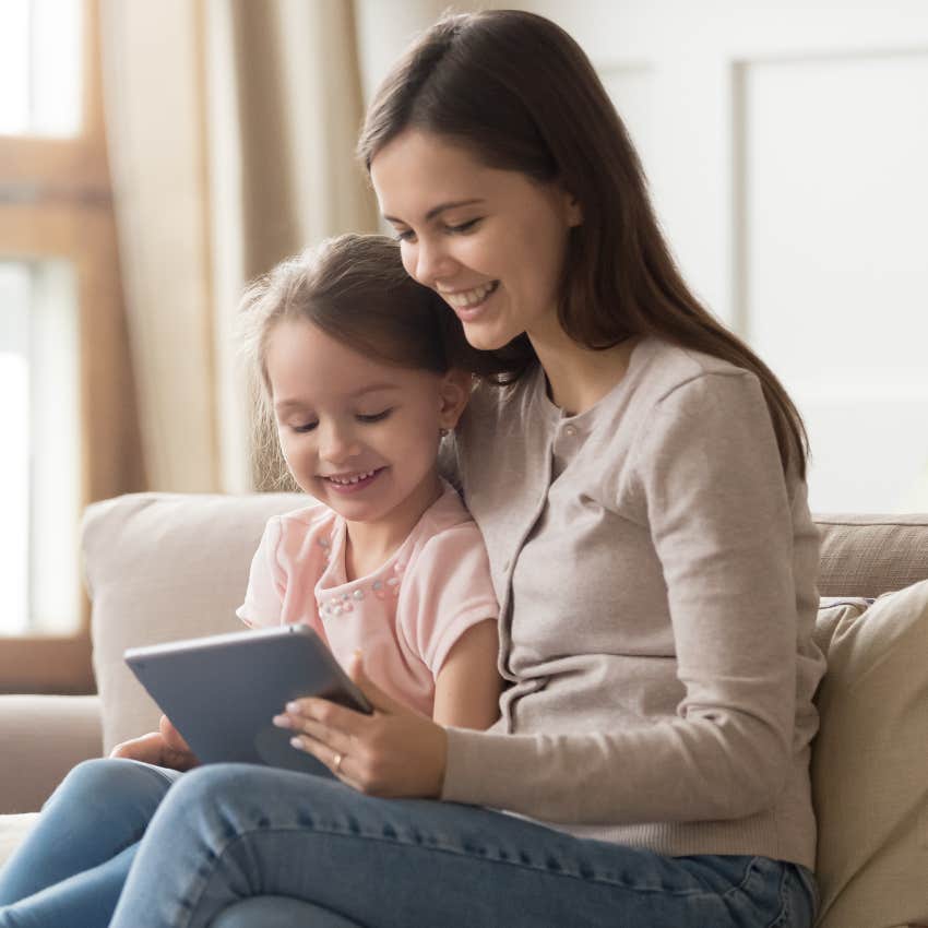 mom helping daughter use tablet for educational program