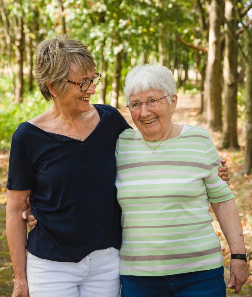 happy elderly person walks with adult daughter 
