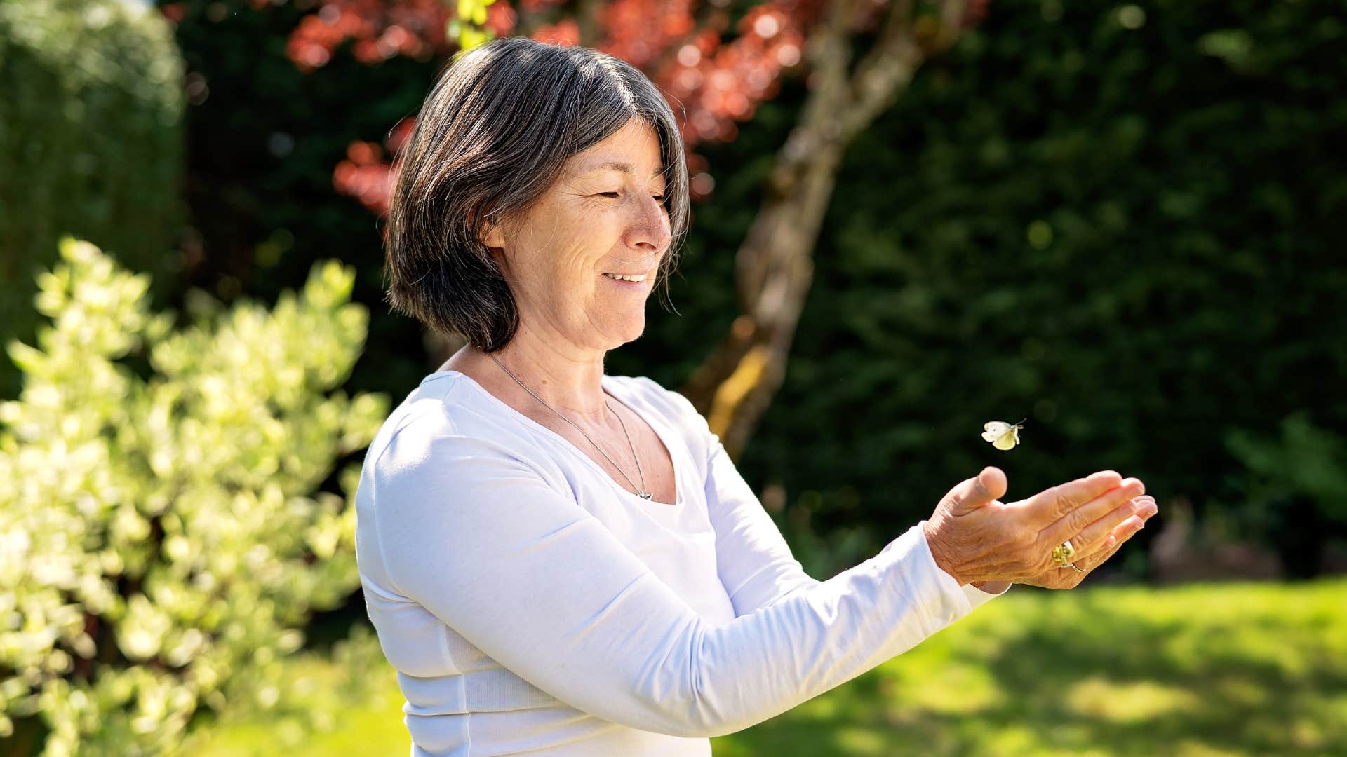 Happy person let's butterfly go from cupped hands