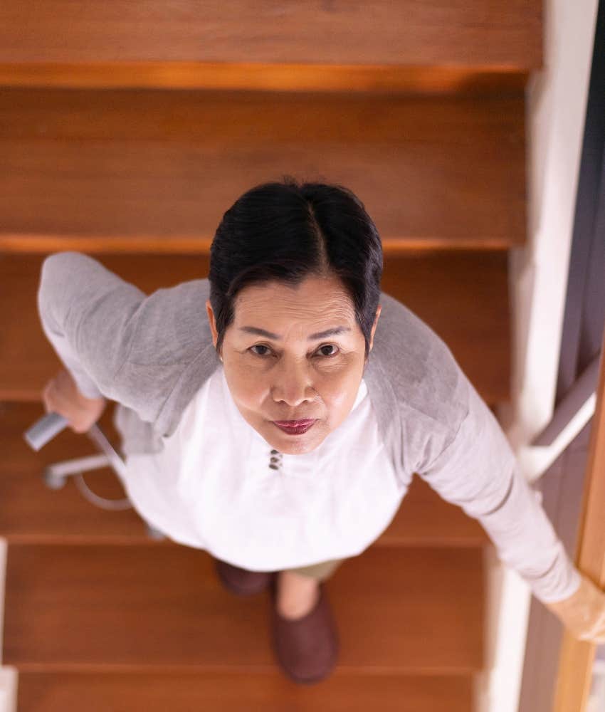 reited pwrson walks down stairs and looks up into camera symbolizing existential crisis