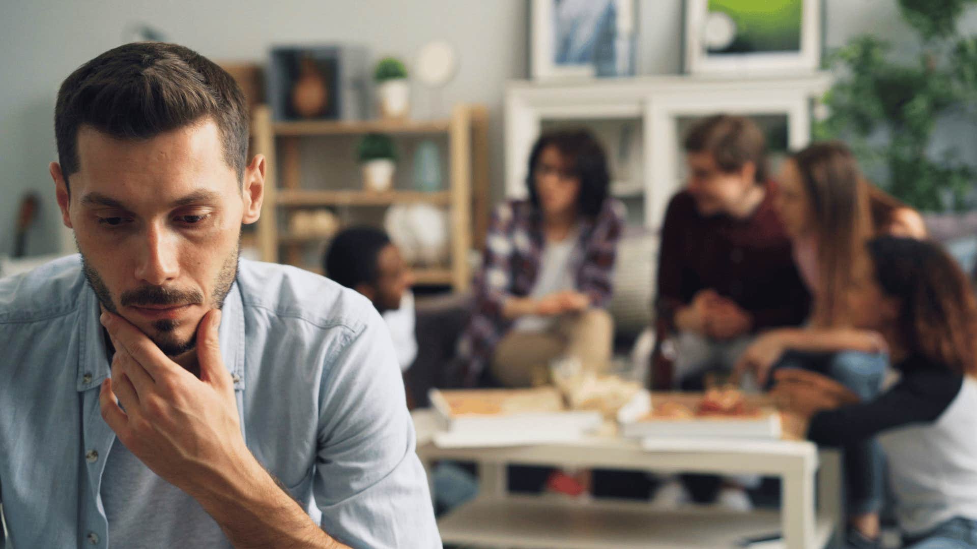 man sitting apart from family feeling off might mean more than sadness
