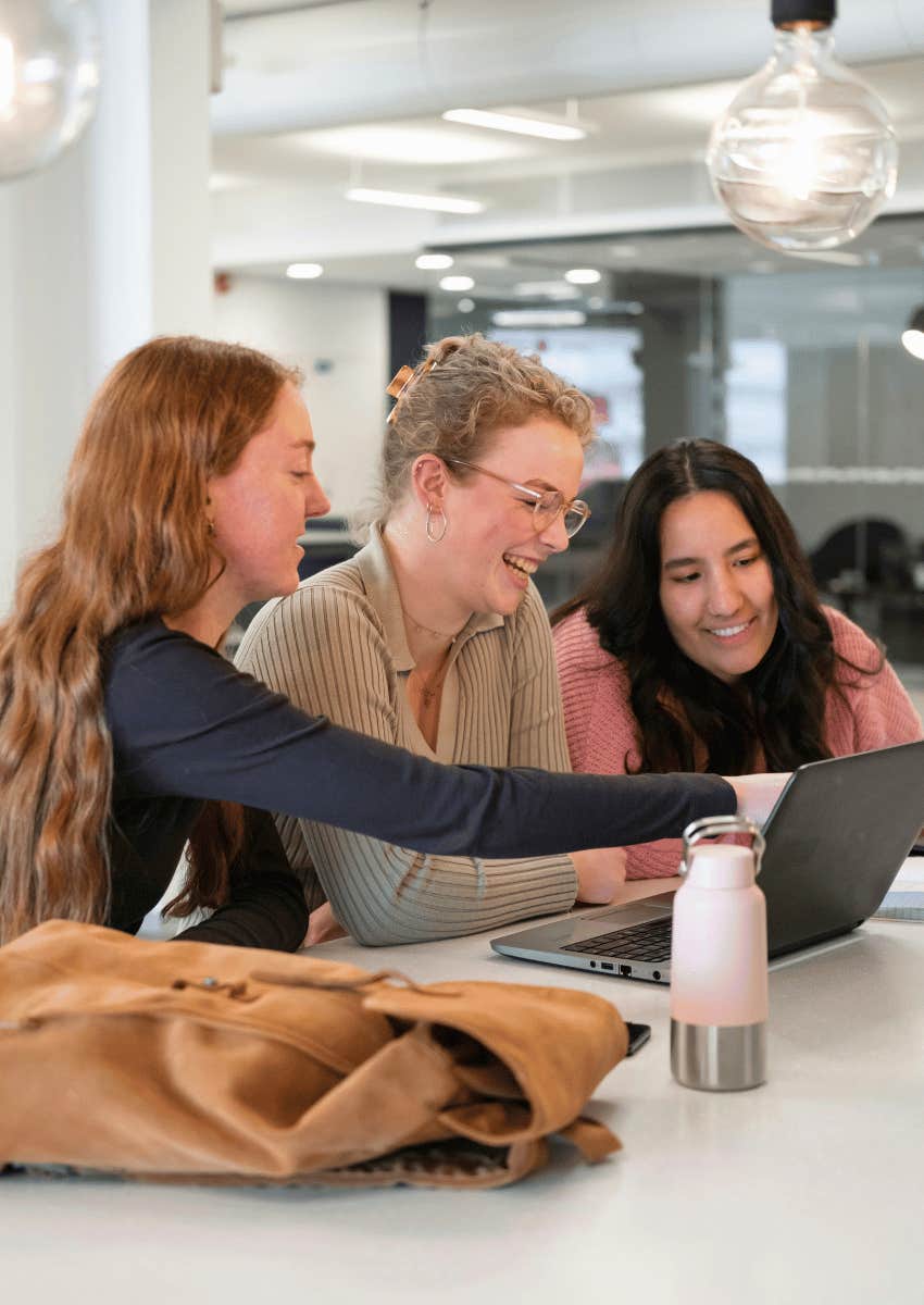 female college students looking at laptop together