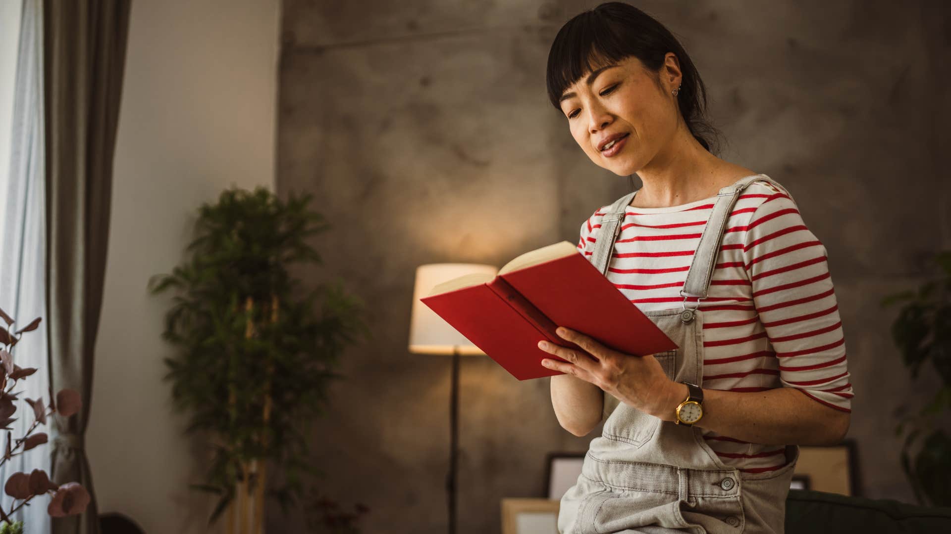 Curious woman reading a book at home.