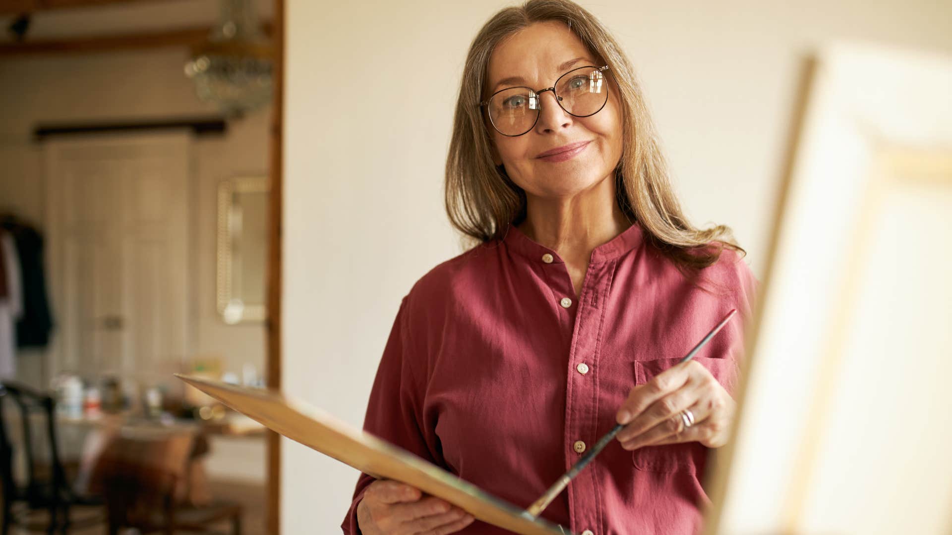 Deeply creative woman painting at home.
