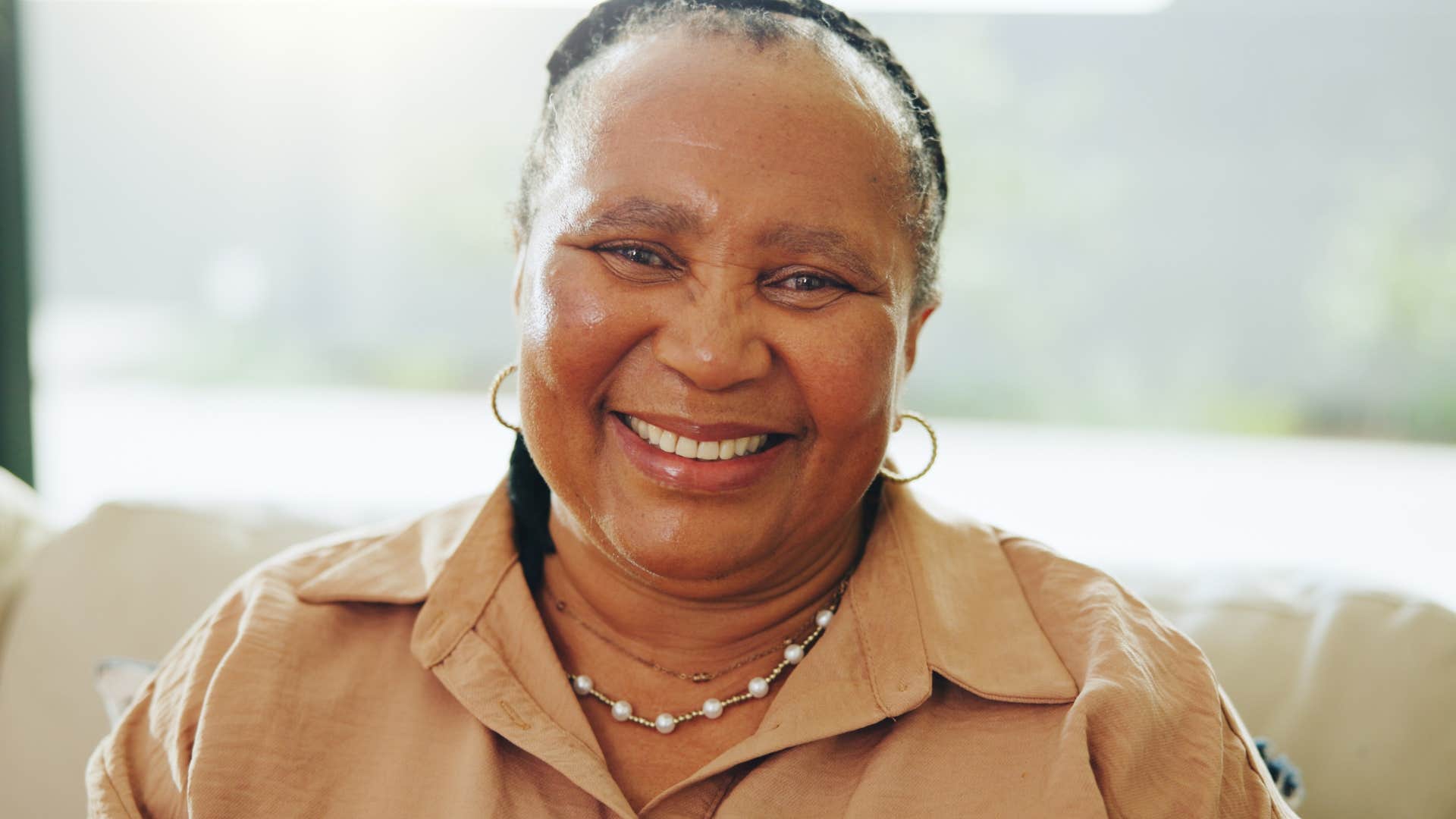 Quietly strong and intentional woman smiling at home.