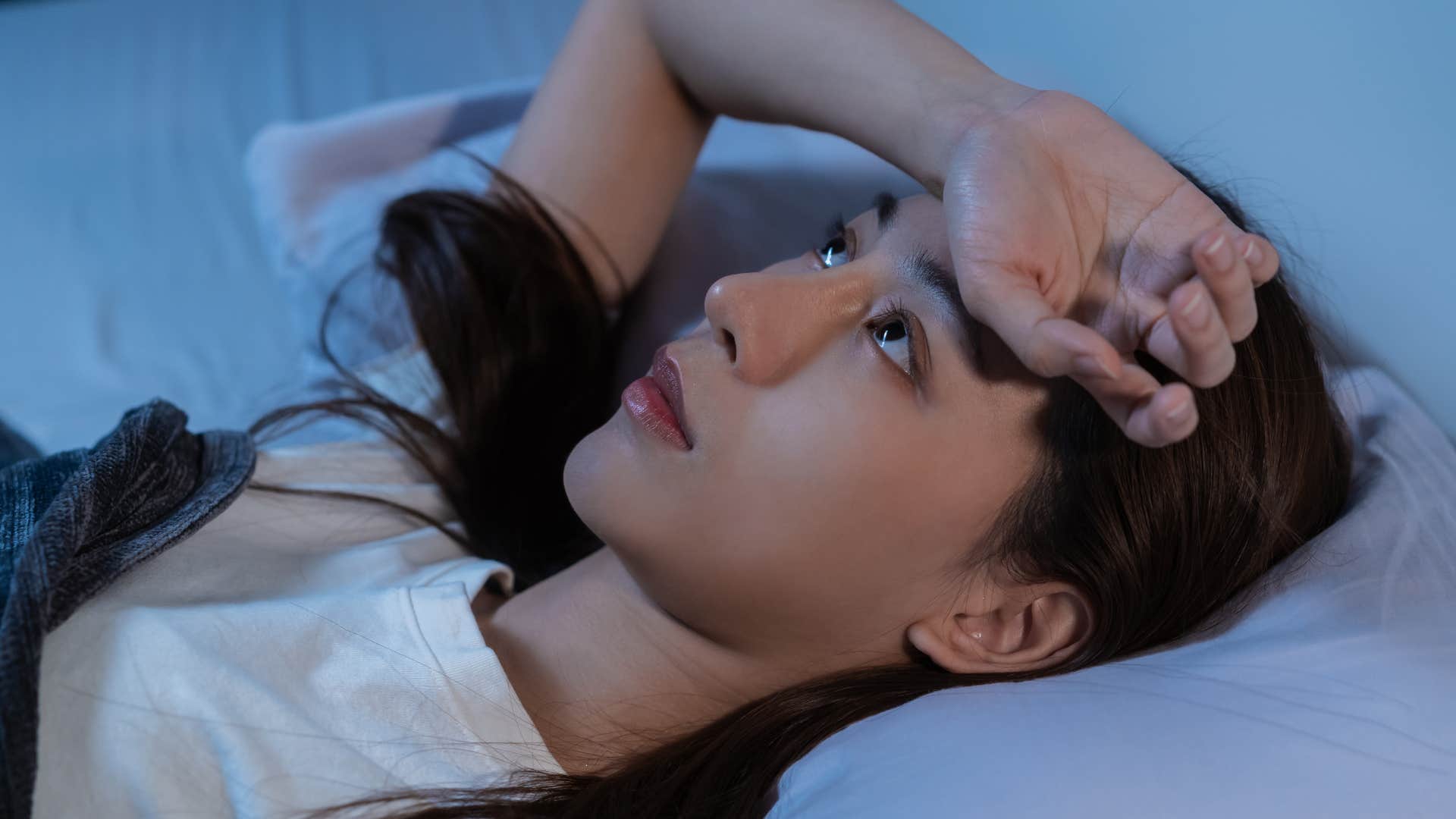 woman reflecting on her day lying in bed at night