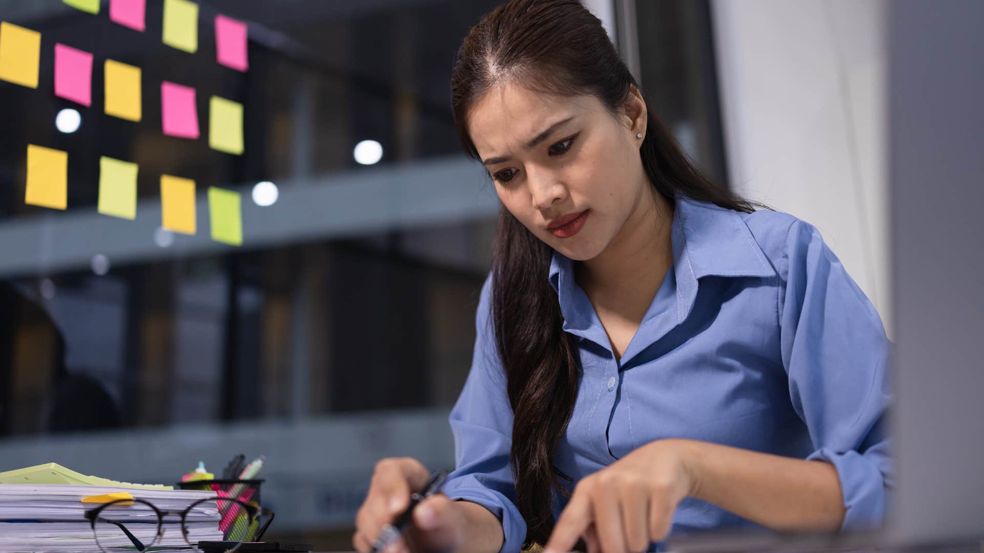 Woman who needs pressure to feel motivated working late.