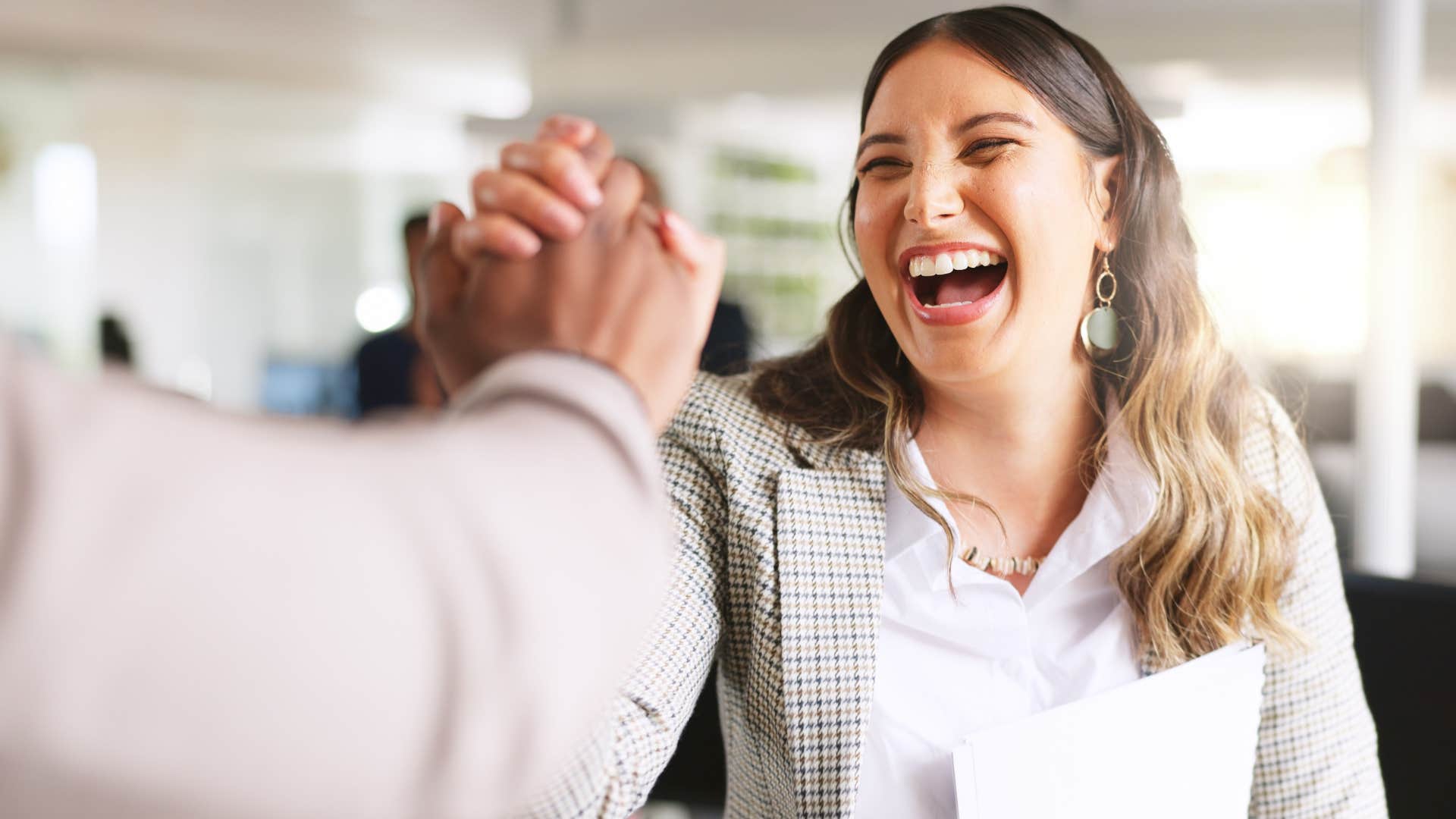 happy woman chasing and realizing goals at work high-fiving colleague
